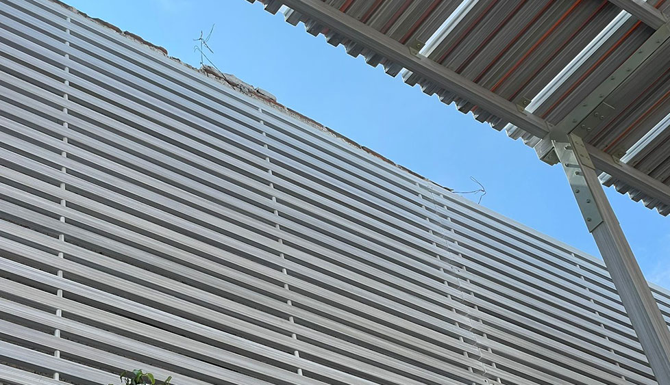 Plafón y celosía blanca de perfiles en fachada exterior